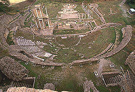 vista aerea del teatro romano: si notano la cavea, la scena e, sullo sfondo, i resti del complesso termale