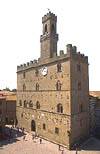 Edificio merlato: il trecentesco Palazzo dei Priori, il pi antico della Toscana, con la caratteristica torre campanaria a pianta pentagonale irregolare